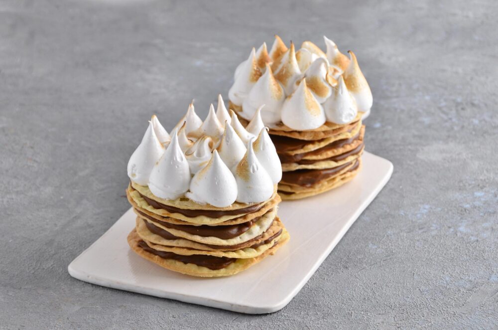 Porción individual de Rogel con finas capas de masa crocante, abundante dulce de leche y merengue italiano de Mada Patisserie en Belgrano.