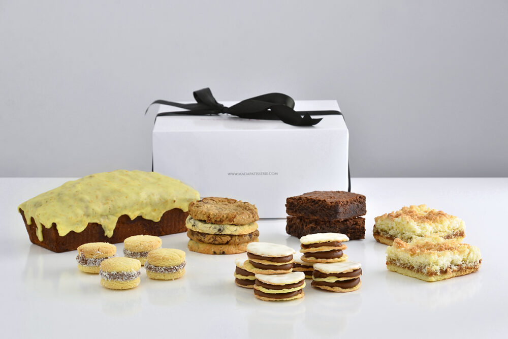 Box dulce de regalo con budín artesanal, rogelitos, alfajores de maicena y cuadrados de brownie y coco de Mada Patisserie en Belgrano.